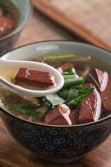 Eating Taiwanese traditional pig blood soup with pickled mustard greens.
