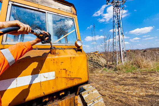 Hand holding handle fuel nozzle to refuel, petrol is pouring into the tank of an industrial mechanization