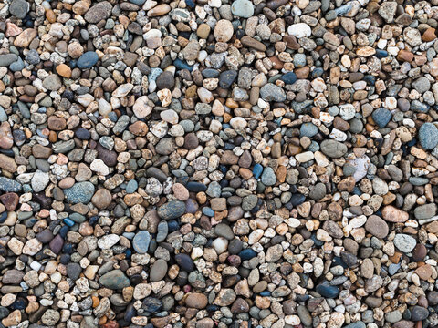 nature background: many small stones of different colors - pebbles on the beach