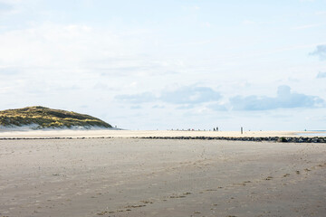 people walking on the sandy beach and dunes of the Wadden Island of Vlieland