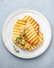 grilled halloumi cheese on a white ceramic plate, top view