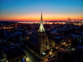 Naklejka premium Church Steeple Against a Sunset River Background