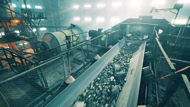 Transportation of copper ore carried out in the factory. Mining industrial conveyor at ore processing factory.