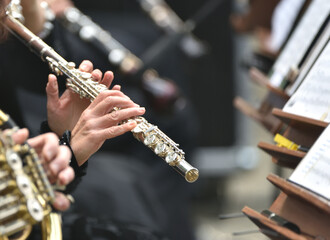 flute in the hands of a musician, during a classical music concert