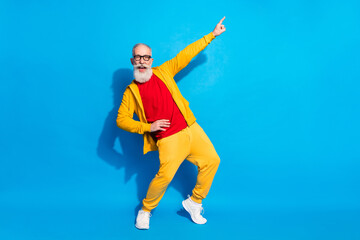 Full size photo of happy good mood cheerful grandfather dancing point finger copyspace isolated on blue color background