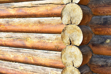 Texture of wall of house made of rounded logs. facade of log house, space for text. Wooden log wall built from smoothly polished logs. Construction of houses from natural materials. Wooden frame 