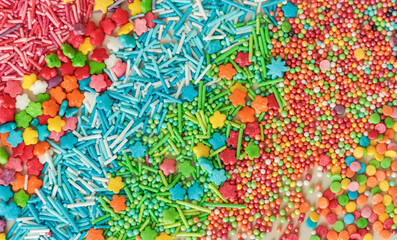 Abstract background of multicolored sugar sprinkles of different shapes for decorating glazed pastries