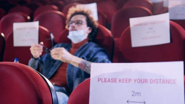 Signs of social distancing in the cinema hall with one man being in it