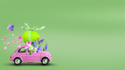 Pink toy car carrying an easter egg and wild flowers on the roof on a green background.