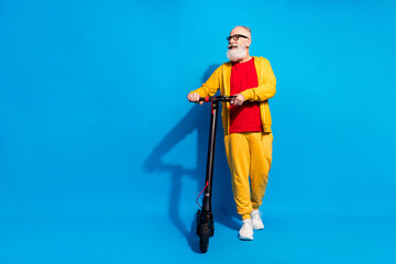 Full body photo of handsome positive person arms hold vehicle look empty space isolated on blue color background