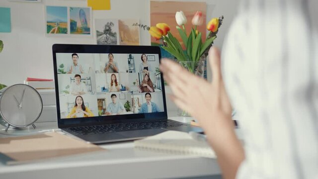 Young asia female employee listen leader on video call with diverse multiracial colleagues on online with laptop at home. Distance learning. Girl student learn online at house, Online meeting concept.