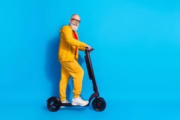 Full length profile photo of candid friendly aged man stand on vehicle look camera isolated on blue color background