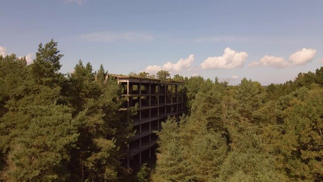 Drone flight upwards of destroyed ruin at KDF Prora on island of R&uuml;gen, Baltic Sea. The ruin is located in a wood.