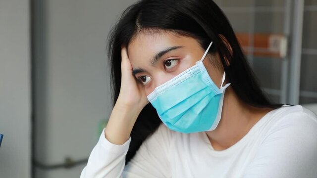 Sick Asian Teen Women Use Medical Face Masks And Blowing Noses While Looking At The Camera. Ill Woman Consulting With A Doctor Online While Sitting On A Sofa At Home. Concept Of Telehealth.