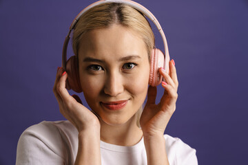 Young happy woman listening to music with headphones