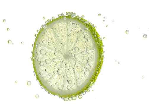 Fresh lime slice in sparkling water on white background
