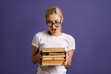 Happy young woman student holding stack of books