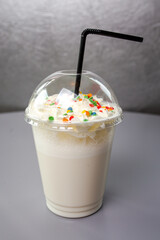 sweet milk cocktail in a plastic glass with a black tuber