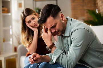 Young man having a problem. Girlfriend comforting her sad boyfriend.