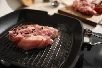Frying pan with fresh raw meat on stove