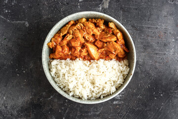 Traditional curry. Tikka Masala chicken and rice. Indian food. Top view. Copy space. Dark background. Isolated