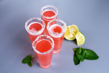 four pink cocktails with lime and mint top view