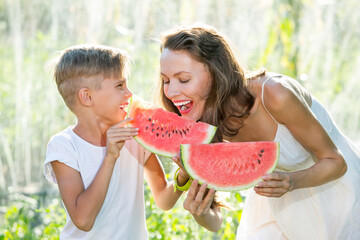 Family eating watermelon outdoors
