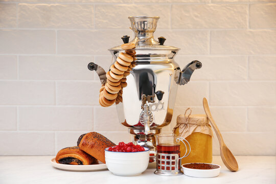 Traditional Russian samovar and treats on white table