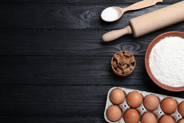 Cooking utensils and ingredients on black wooden table, flat lay. Space for text