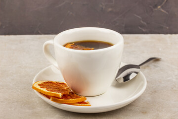 Cup of coffee on a neutral background with citrus chips