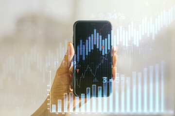 Multi exposure of abstract creative financial chart and hand with cell phone on background, research and analytics concept