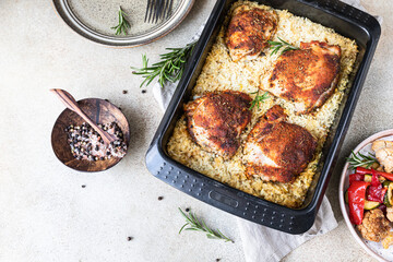 Baked chicken meat with rice in a baking dish served with roasted vegetables. Oven baked chicken meat with rice. Top view.
