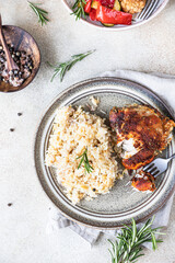 Baked chicken breast with rice on a plate served with roasted vegetables. Top view.