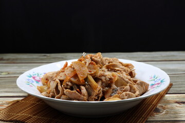 Classic fried and stirred pork meat with kimchi (Korea pickled vegetable) serving on the plate. Famous traditional menu in Asian restaurant. 