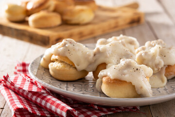 Traditional American biscuits and gravy for breakfast on wooden table