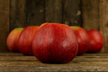 Fototapeta na wymiar Ripe, red, juicy apples on a brown, old background.