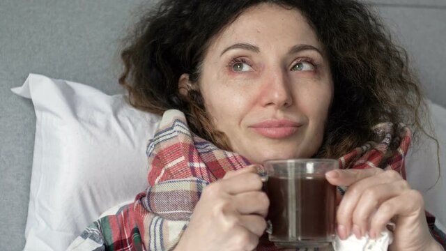 Sick woman drinking herbal tea. Vitamin and hot tea for flu, colds, coronavirus or diarrhea.