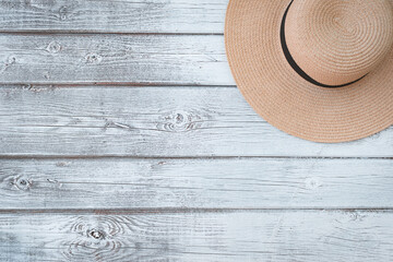 Top view of a white wooden straw hat background with copy space.