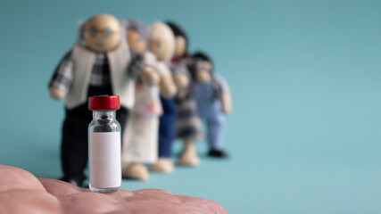 Ampoule with vaccine on human arm . A vaccination queue made up of dolls of different ages, concept. Copy space... Banner