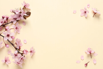 Obraz na płótnie Canvas Sakura tree branch with beautiful pink blossoms on beige background, flat lay. Space for text