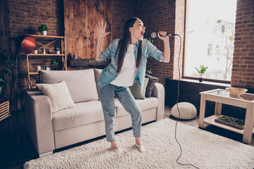 Obraz premium Full length photo of attractive happy young woman sign song good mood microphone indoors inside home