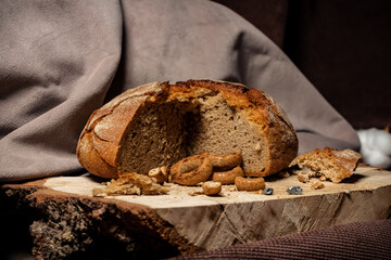 Bread and drying lie on a wooden board on a dark background