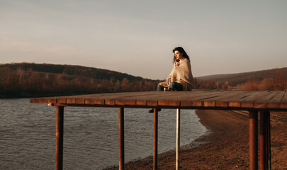 Woman resting on pier in autumn evening