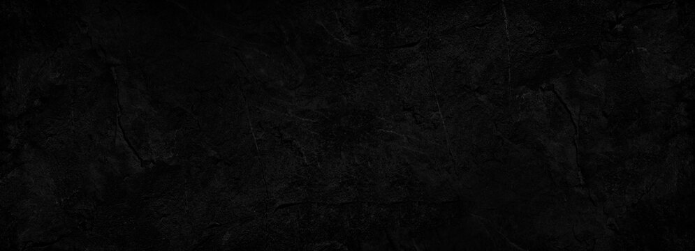 Black abstract background. Dark rock texture. Black stone background with copy space for design. Web banner. Wide. Panoramic.