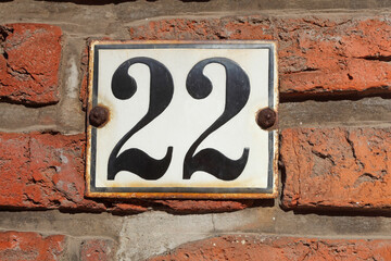 Altes Hausnummernschild Nummer Zweiundzwanzig, Backsteinmauer, Deutschland