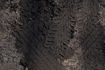 the muddy road is dry in the sun and plays an interesting pattern and imprints