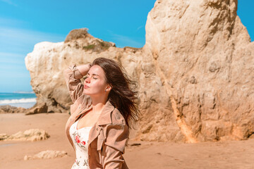 Beautiful woman in dress on Matador Beach near Los Angeles, beautiful rocks and ocean