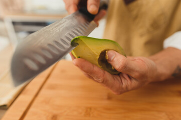 vegan sushi. Close up wide angle asian sushi master slicing avocado with knife 