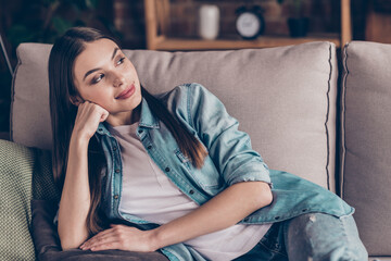Obraz premium Photo of relaxed happy young charming lady look away lie sofa weekend good mood indoors inside house flat