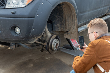 Obraz na płótnie Canvas a man takes a photo of the brake disc of a car